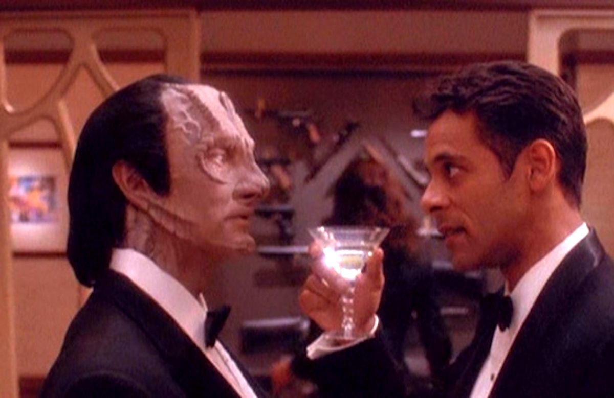 Star Trek: Deep Space Nine'da Bashir bir martini bardağını Garak'a kaldırırken Bashir ve Garak resmi kıyafetler içinde.