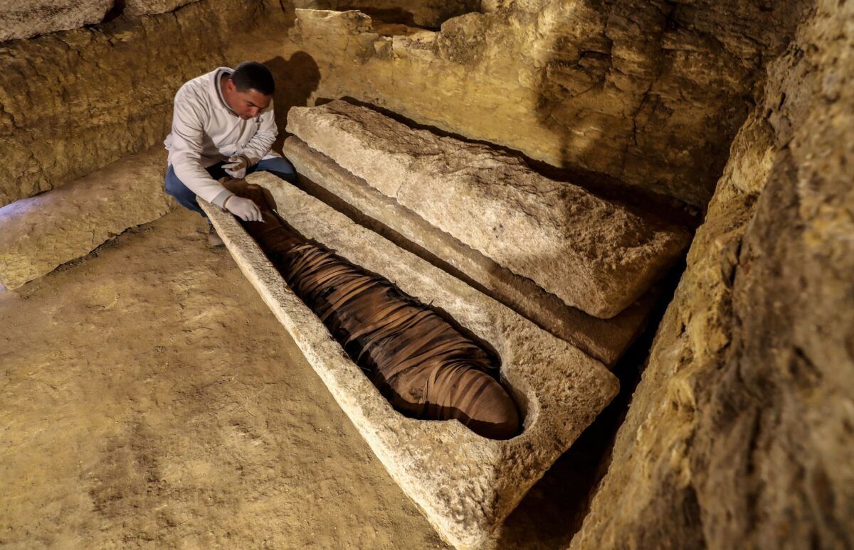 Mısırlı bir arkeolog, 30 Ocak 2020'de Minya vilayetindeki Tuna al-Jabal'daki Al-Ghoreifa'da yüksek rahiplere adanmış 3000 yıllık toplu mezarlarda bulunan birçok buluntu arasında bulunan kireçtaşı lahitteki mumyayı inceliyor. - Mısır