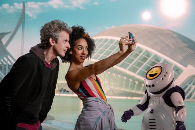 Resim gösterileri: Doktor olarak Peter Capaldi, Bill olarak Pearl Mackie ve bir Emojibot