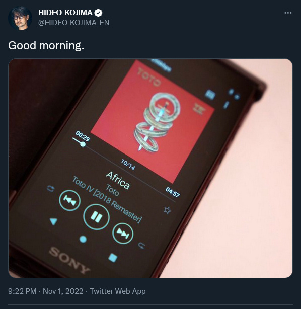   Hideo Kojima ukazuje svoj smartfón pri počúvaní Toto's Africa.