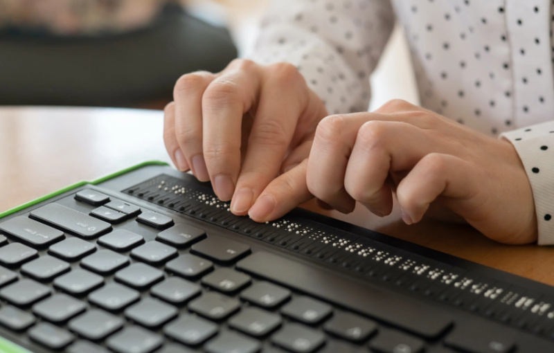   Prim-plan asupra unei femei's hands using a braille keyboard.