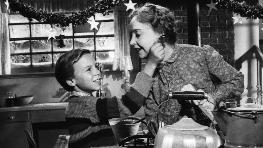 סטילס מתוך ליל הצייד המציג ילד ואישה מבוגרת שמבשלים יחד עם קישוטי חג המולד ברקע