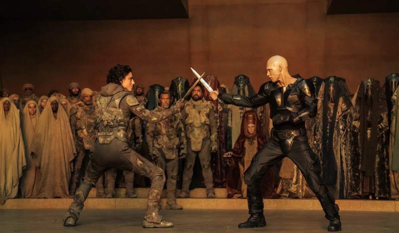  Feyd-Rautha Harkonnen (Austin Butler) et Paul (Timothée Chalamet debout avec des épées l'un en face de l'autre dans Dune