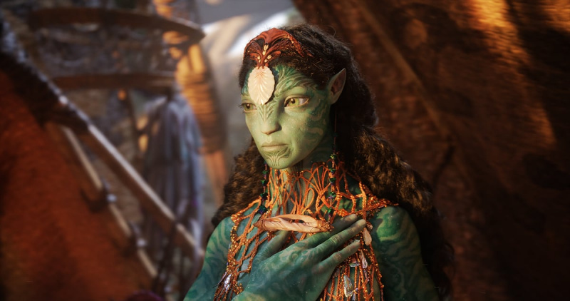   Ronal, ein Na'vi with a large shell on her forehead, puts her hand on her chest in Avatar: The Way of Water.