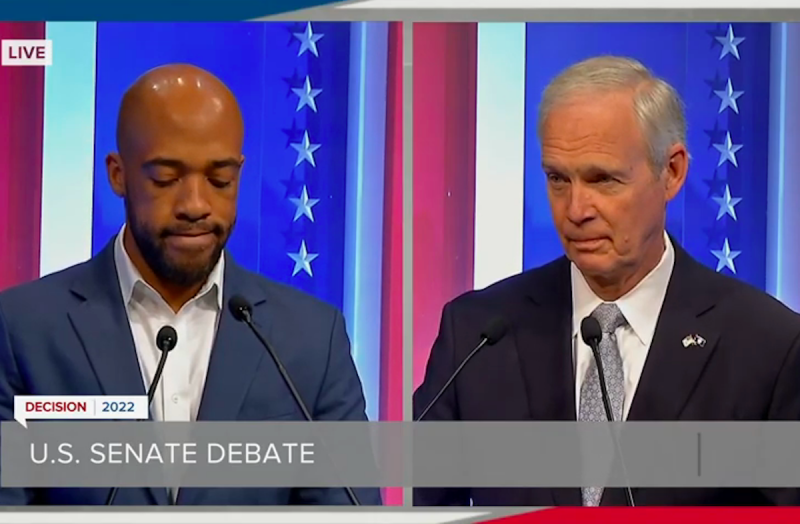   Mandela Barnes en Ron Johnson in splitscreen staan ​​op podia tijdens een debat.