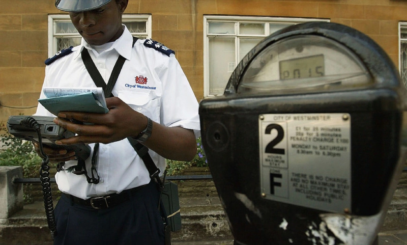  ЛОНДОН - 7. ЈУЛИ: Саобраћајни управник из Вестминстера издаје казну за паркирање 7. јула 2004. у Лондону, Енглеска. Новац прикупљен у Енглеској од казни за паркирање, бројила, шема за паркирање у стамбеним објектима и фиксних казни достигао је скоро милијарду ГБП годишње, а лондонски возачи доприносе скоро половину укупног износа.