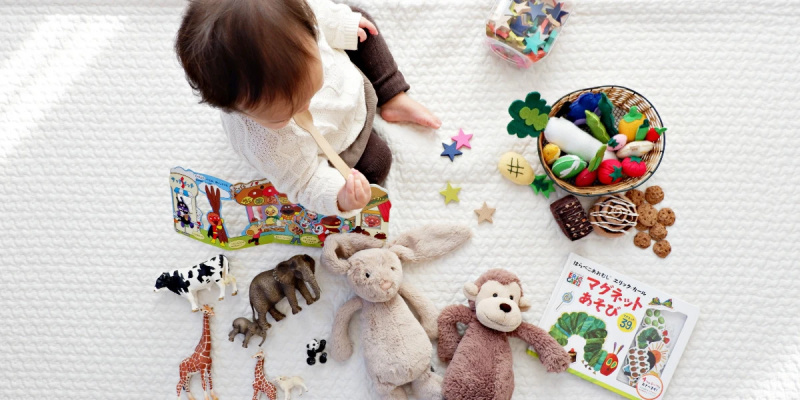  Un niño pequeño que juega con varios juguetes en una alfombra blanca
