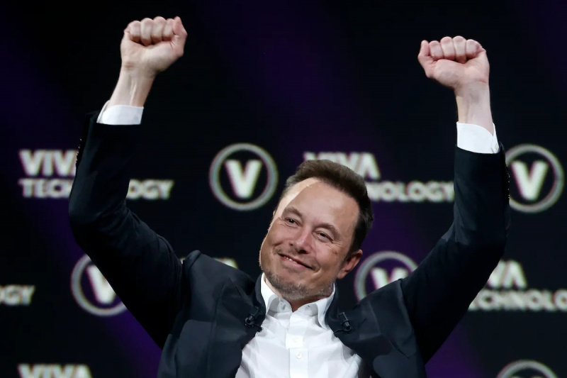  Elon Musk hrnky a drží pěsti nad hlavou jako vítězně.