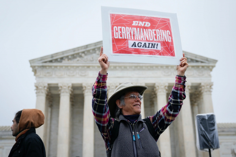  Активиста за права гласа стоји испред Врховног суда држећи натпис који чита"Stop gerrymandering again"