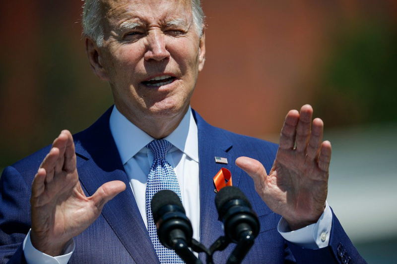  Joe Biden habla desde un podio, levantando las manos con un"wait a minute" gesture
