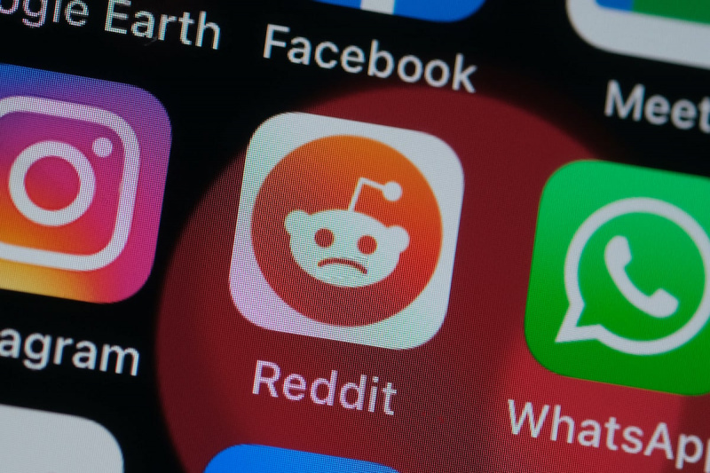   На овој фото илустрацији, логотип Реддит-а се види на екрану паметног телефона, али мали ванземаљац's usual smile is a frown.