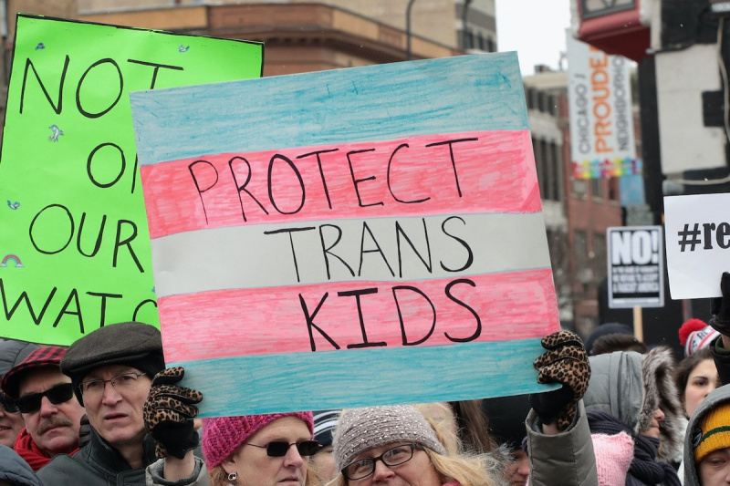   En una protesta por los derechos de las personas transgénero, una persona sostiene un cartel que dice"Protect trans kids"