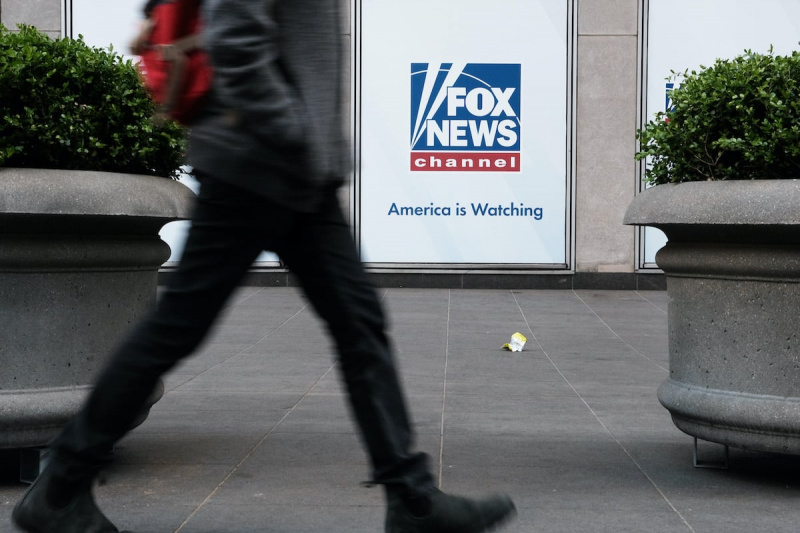   Belden aşağısı görülen bir kişi Fox News ofisinin önünden geçiyor.
