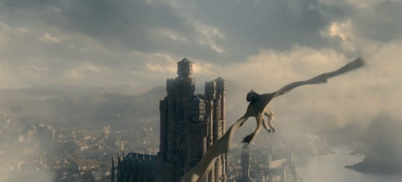   Een screenshot van de trailer voor House of the Dragon, Game of Thrones' prequel series, featuring a Targaryen dragonknight on top of a dragon flying over King's Landing