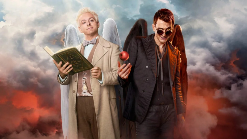   Michael Sheen como Aziraphale y David Tennant como Crowley en Good Omens. Aziraphale sostiene un libro, mientras que Crowley sostiene una manzana. Las nubes están detrás de ellos.