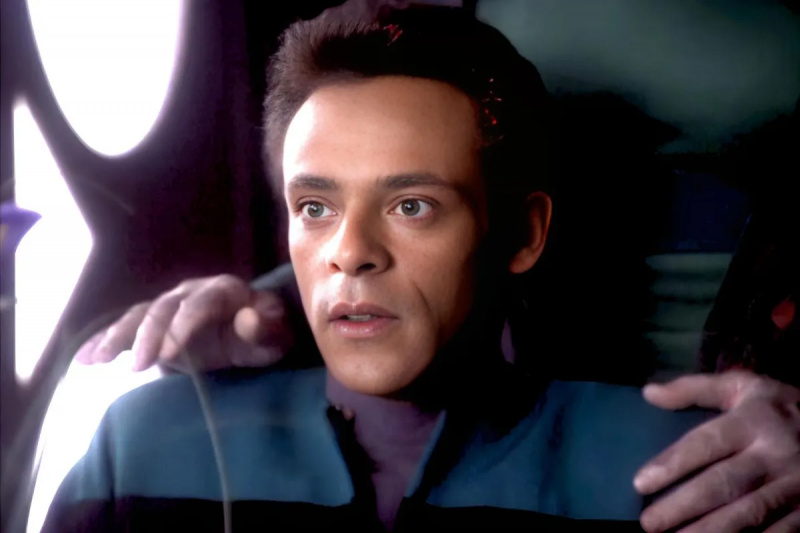   Alexander Siddig, Julian Bashir rolünde Garak'a sahip olmasına şaşırmış görünüyor's hands on his shoulders on 'Star Trek: Deep Space Nine'