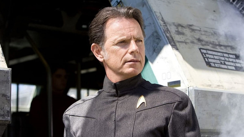   Bruce Greenwood como Capitán Pike en una escena de 2009's 'Star Trek.' He is a middle-aged white man with short, brown hair wearing a grey Starfleet uniform.