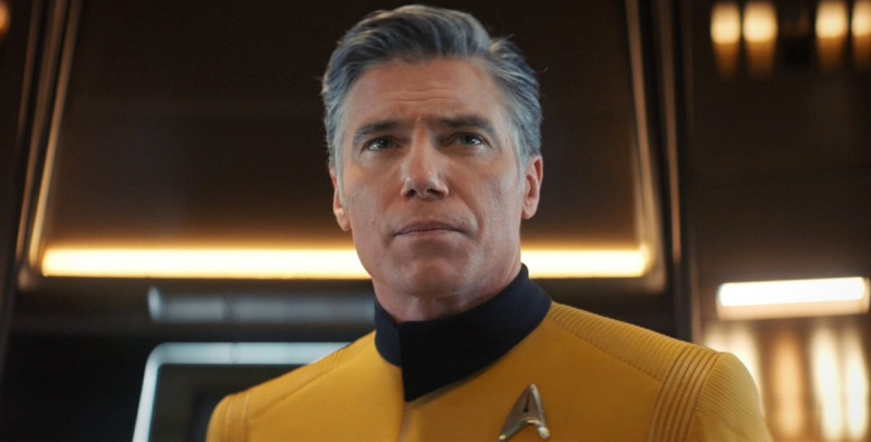   El Capitán Christopher Pike interpretado por Anson Mount en una escena de'Discovery.' He is a white man with mostly silver salt and pepper hair, wearing a gold Starfleet uniform. He looks concerned.