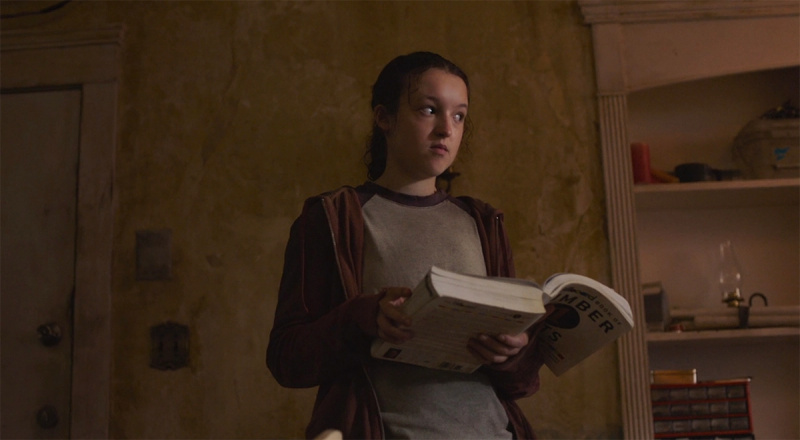  Ellie Williams (Bella Ramsey) sosteniendo un libro sobre canciones en su mano sobre'The Last of Us'